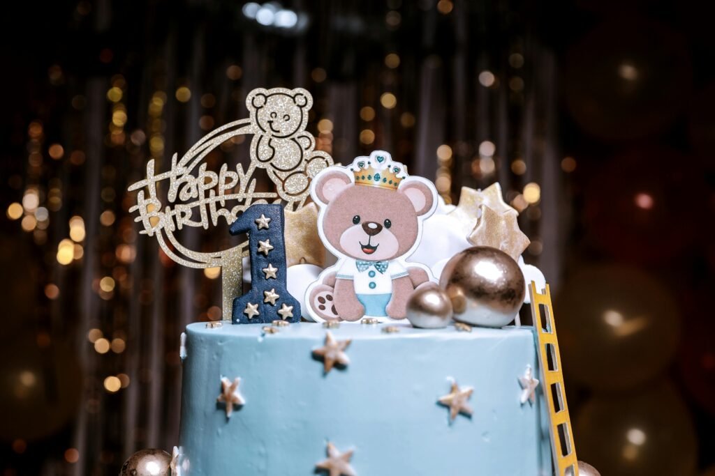 Adorable blue cake with teddy bear topper for a first birthday celebration, perfect for kids parties.