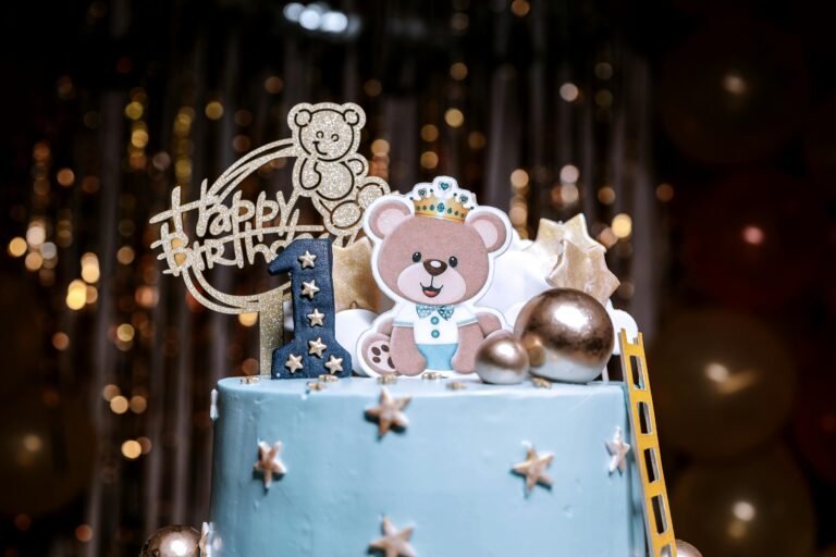 Adorable blue cake with teddy bear topper for a first birthday celebration, perfect for kids parties.