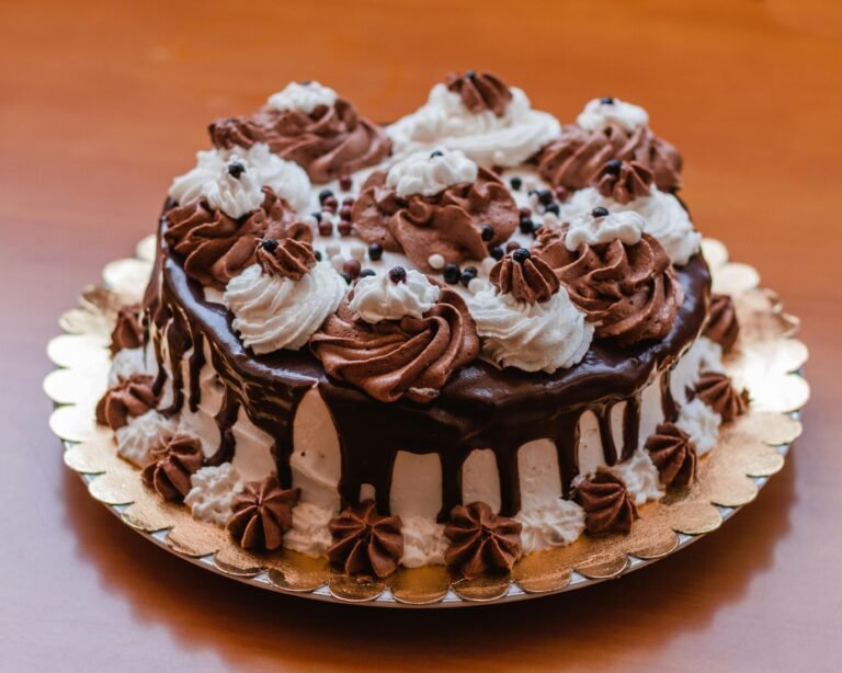 A delectable chocolate drip cake adorned with chocolate and vanilla whipped topping, perfect for dessert lovers.