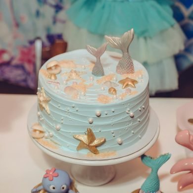 A whimsical mermaid-themed cake adorned with sea-inspired decorations perfect for birthday celebrations.